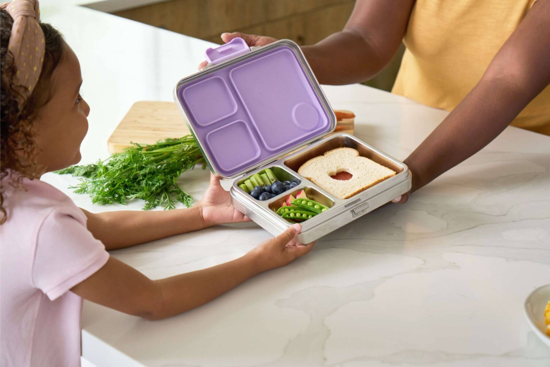 Family preparing lunch in a kitchen using Good Bare stainless steel bento containers 