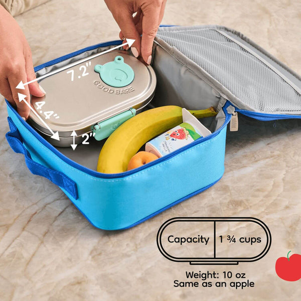 Stainless steel snack box with food items and measurements on a wooden surface