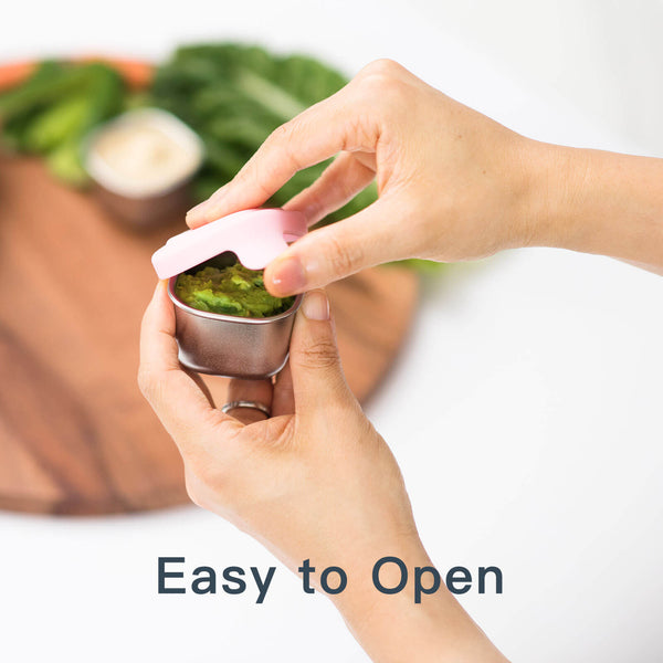 Hand opening a small sauce container with a lid